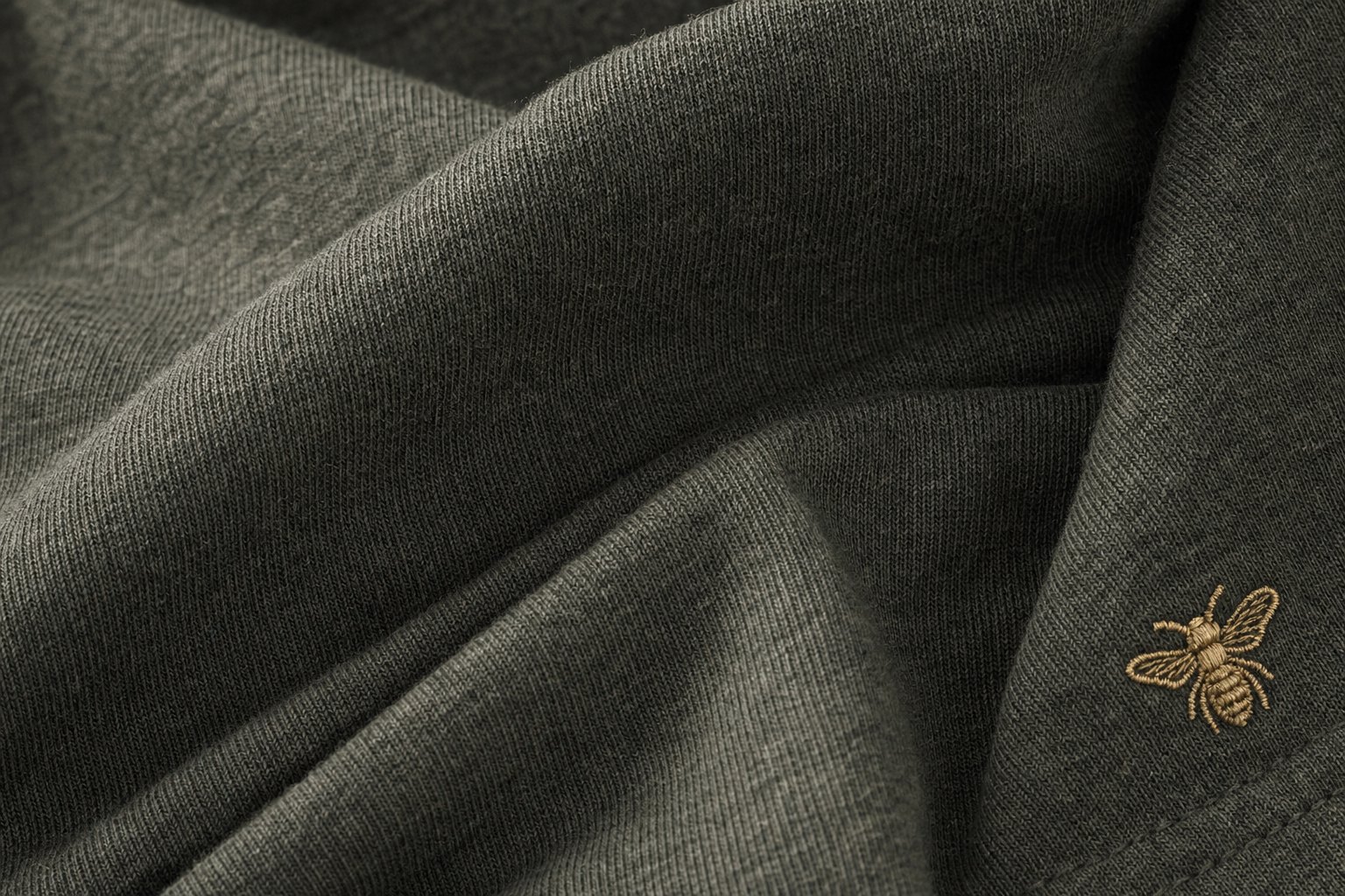 Field Olive knit with honey-gold bee embroidery, macro